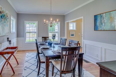 A dining room with a table and chairs and a chandelier.