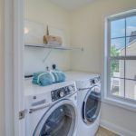A laundry room with a washer and dryer and a window.