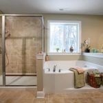 A bathroom with a tub , shower , and window.