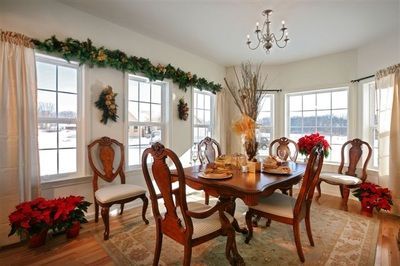 A dining room with a table and chairs decorated for christmas