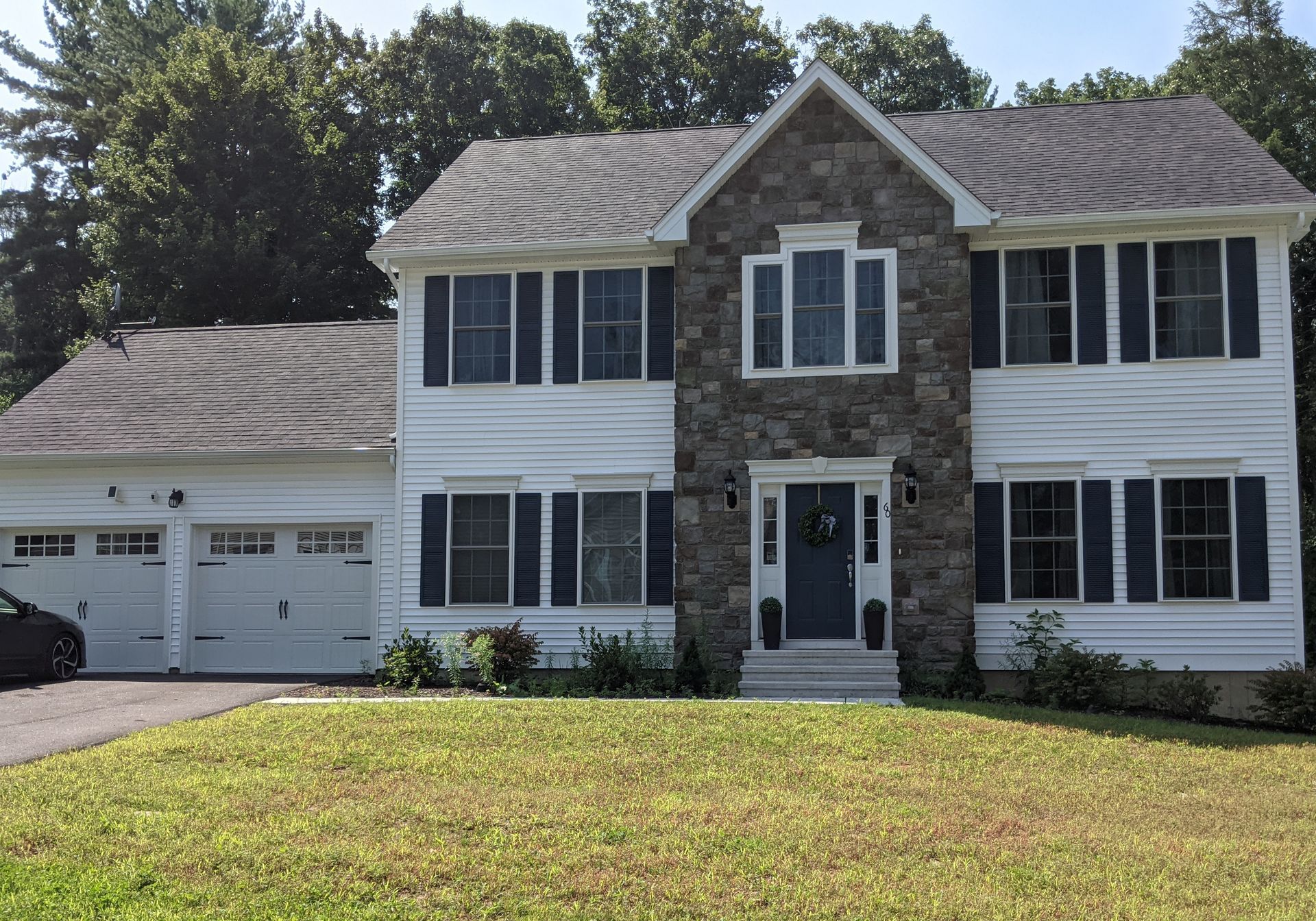 A large white house with a car parked in front of it