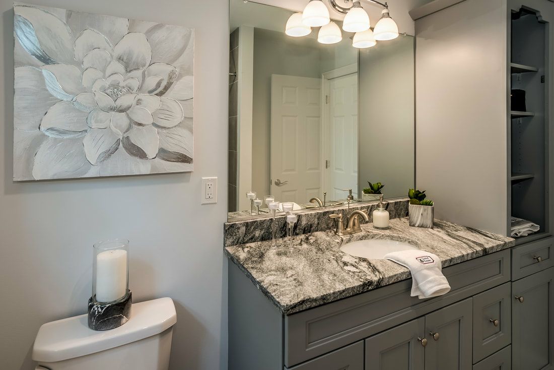 A bathroom with a toilet , sink , and mirror.