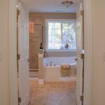 A bathroom with a tub , shower , and window.