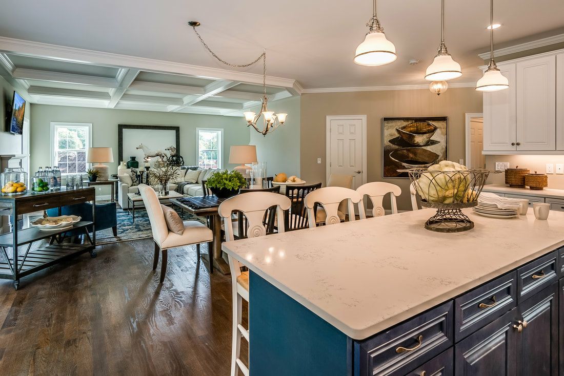 A kitchen with a large island and a dining room in the background.
