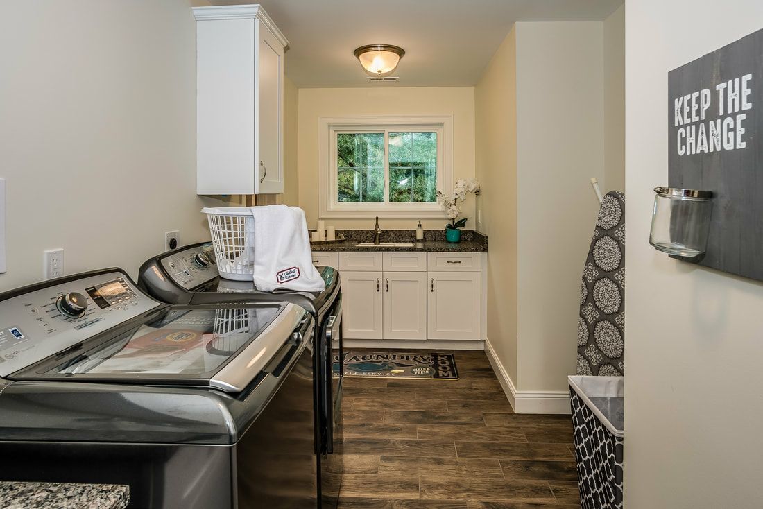 A laundry room with a washer and dryer and a sign on the wall that says `` keep the change ''.