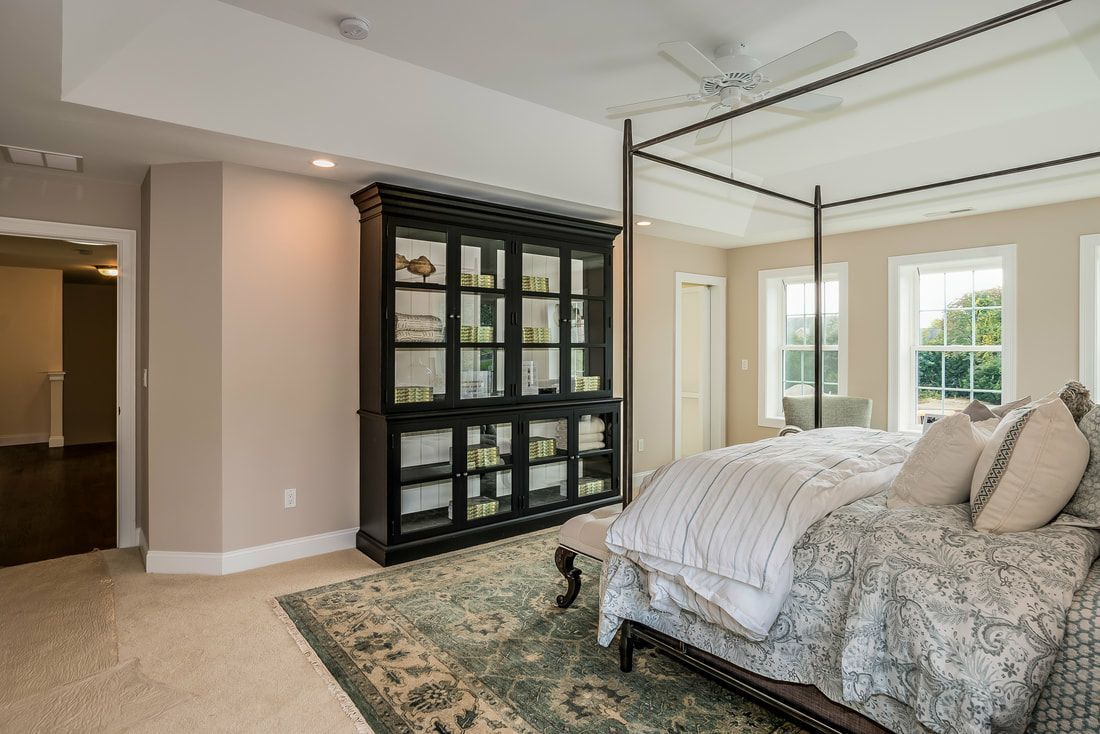 A bedroom with a canopy bed and a bookcase.
