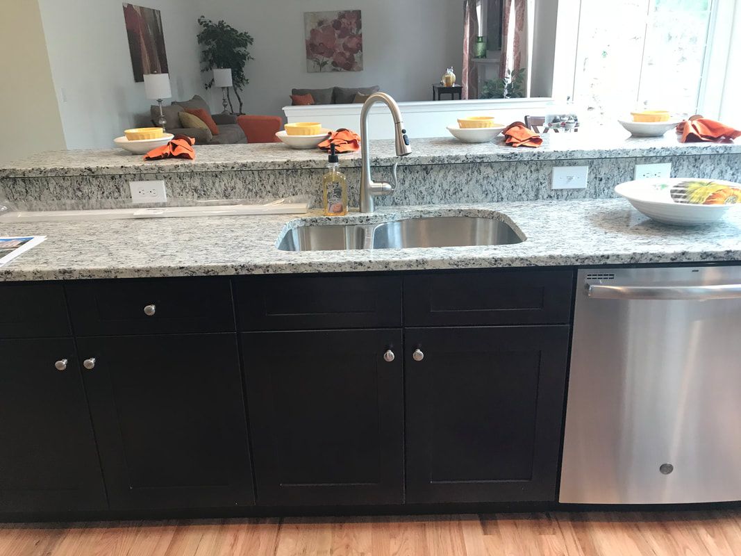 A kitchen with two sinks and a stainless steel dishwasher.