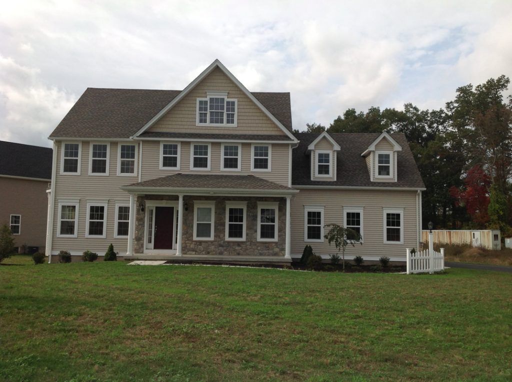 A large house with a lot of windows and a white fence
