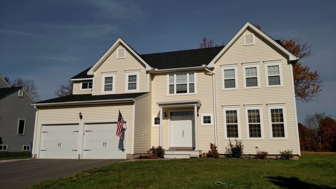 A large white house with a black roof