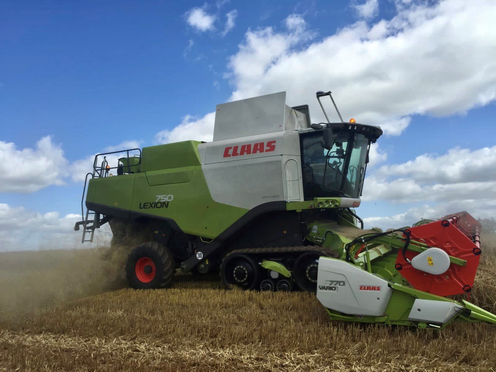 a claas combine harvester is working in a field