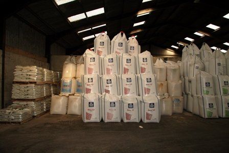 a large warehouse filled with lots of bags of fertilizer .