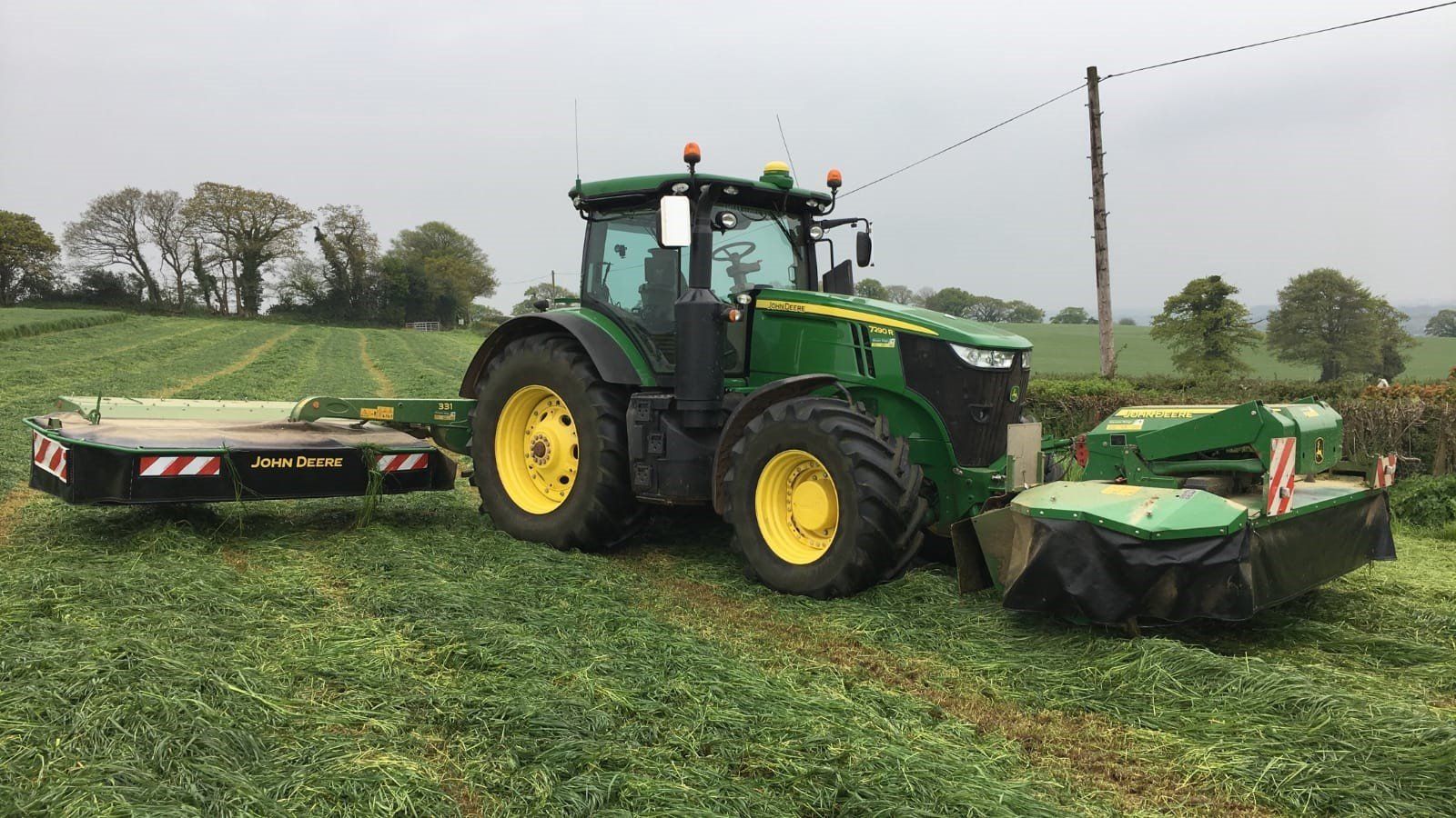a john deere tractor is parked in a grassy field
