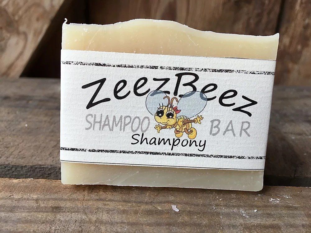 a zee beez shampoo bar sits on a wooden surface