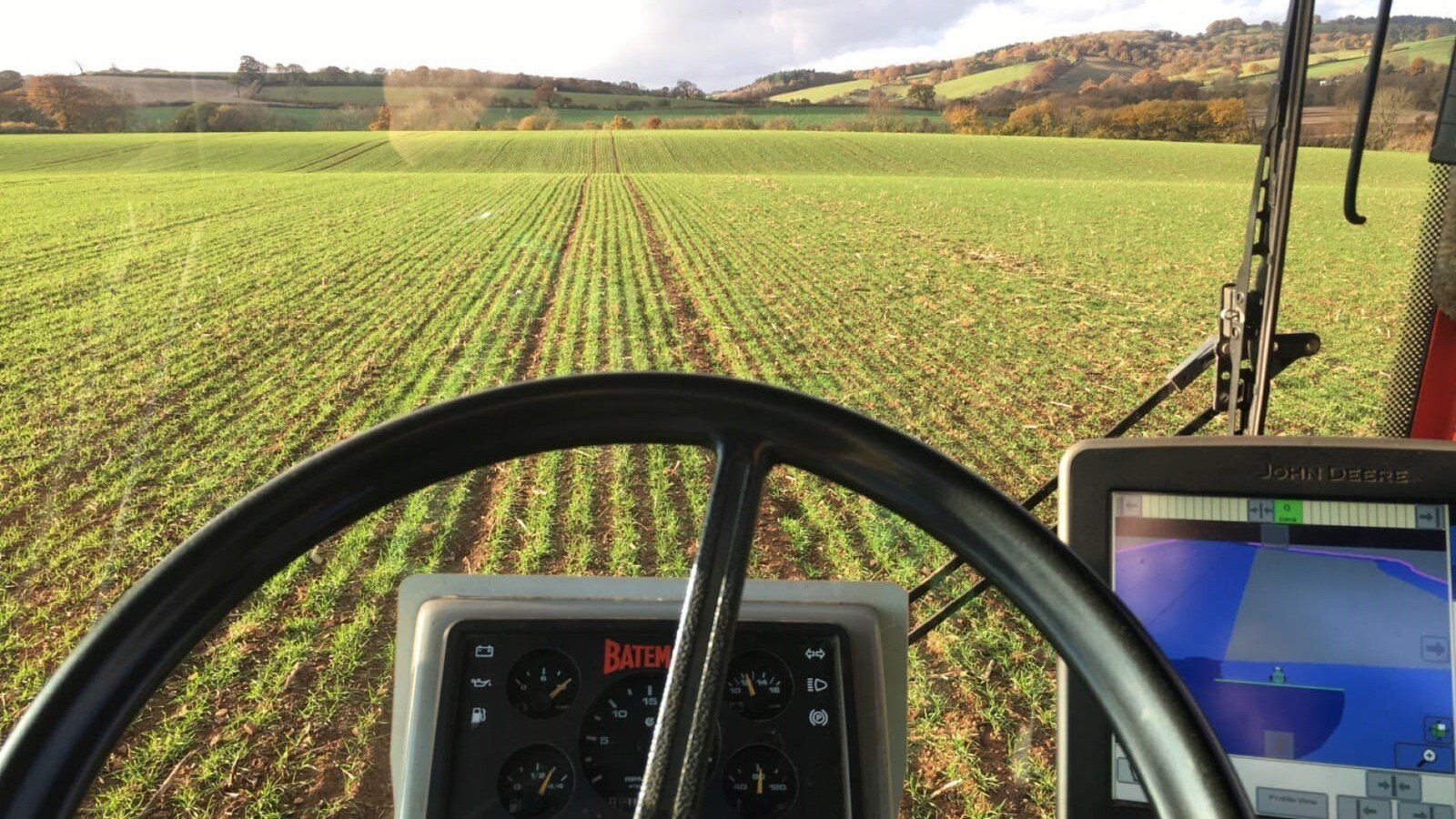 a john deere tractor is driving through a field