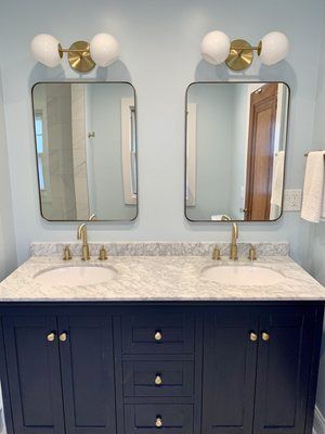 A bathroom with two sinks and two mirrors.