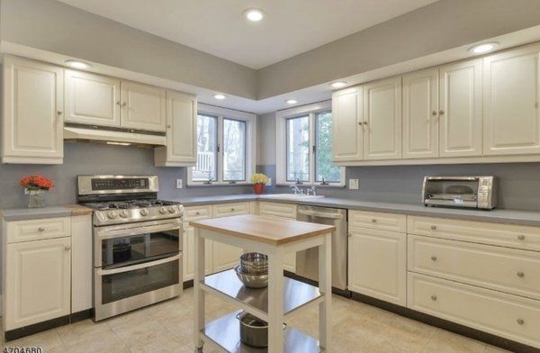 A kitchen with white cabinets and stainless steel appliances