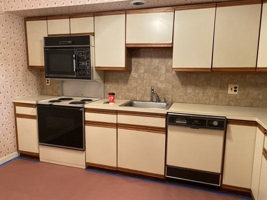 A kitchen with a stove , microwave , sink and dishwasher