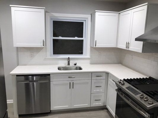A kitchen with white cabinets and stainless steel appliances