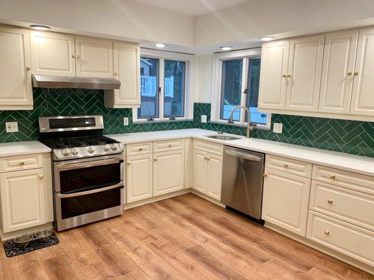 A kitchen with white cabinets , a stove and a dishwasher.
