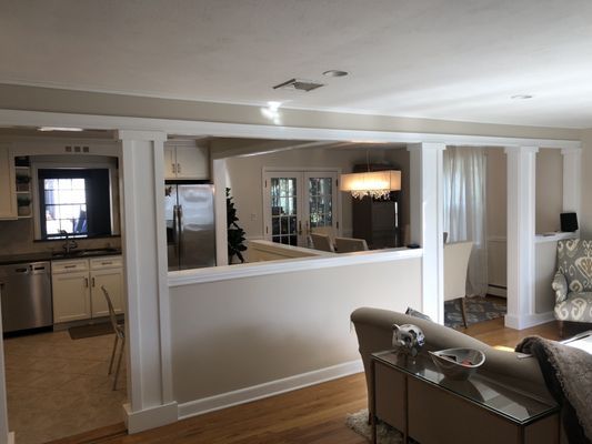 A living room with a couch and a kitchen in the background.