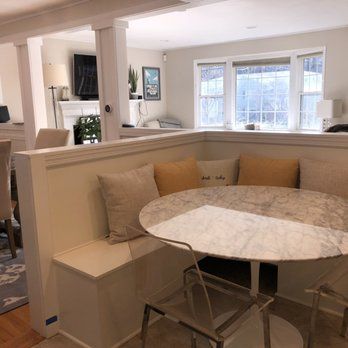 There is a table and chairs in the corner of the room.