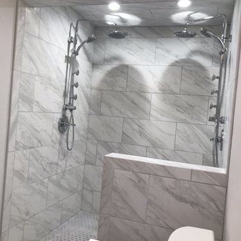 A bathroom with two shower heads and a toilet.
