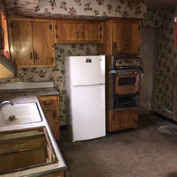 A kitchen with a refrigerator , sink , stove and oven.