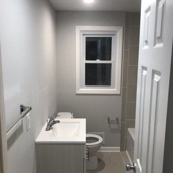 A bathroom with a sink , toilet , and window.