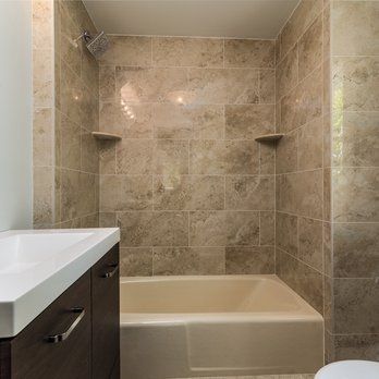 A bathroom with a tub , sink , toilet and shower.
