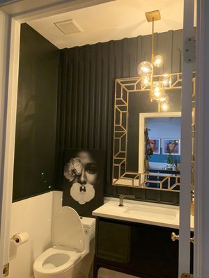 A bathroom with a toilet , sink and mirror.