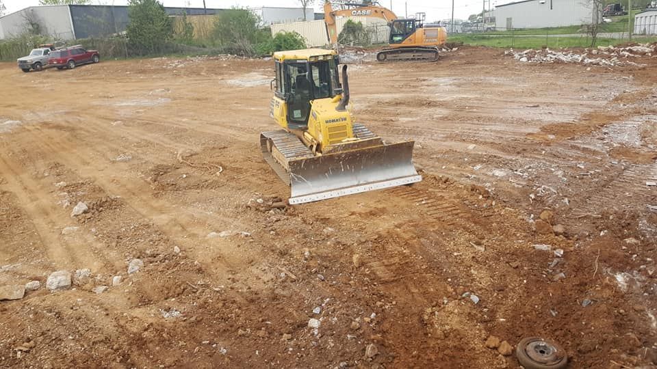Bulldozer on a construction site, pushing dirt. Cloudy day.