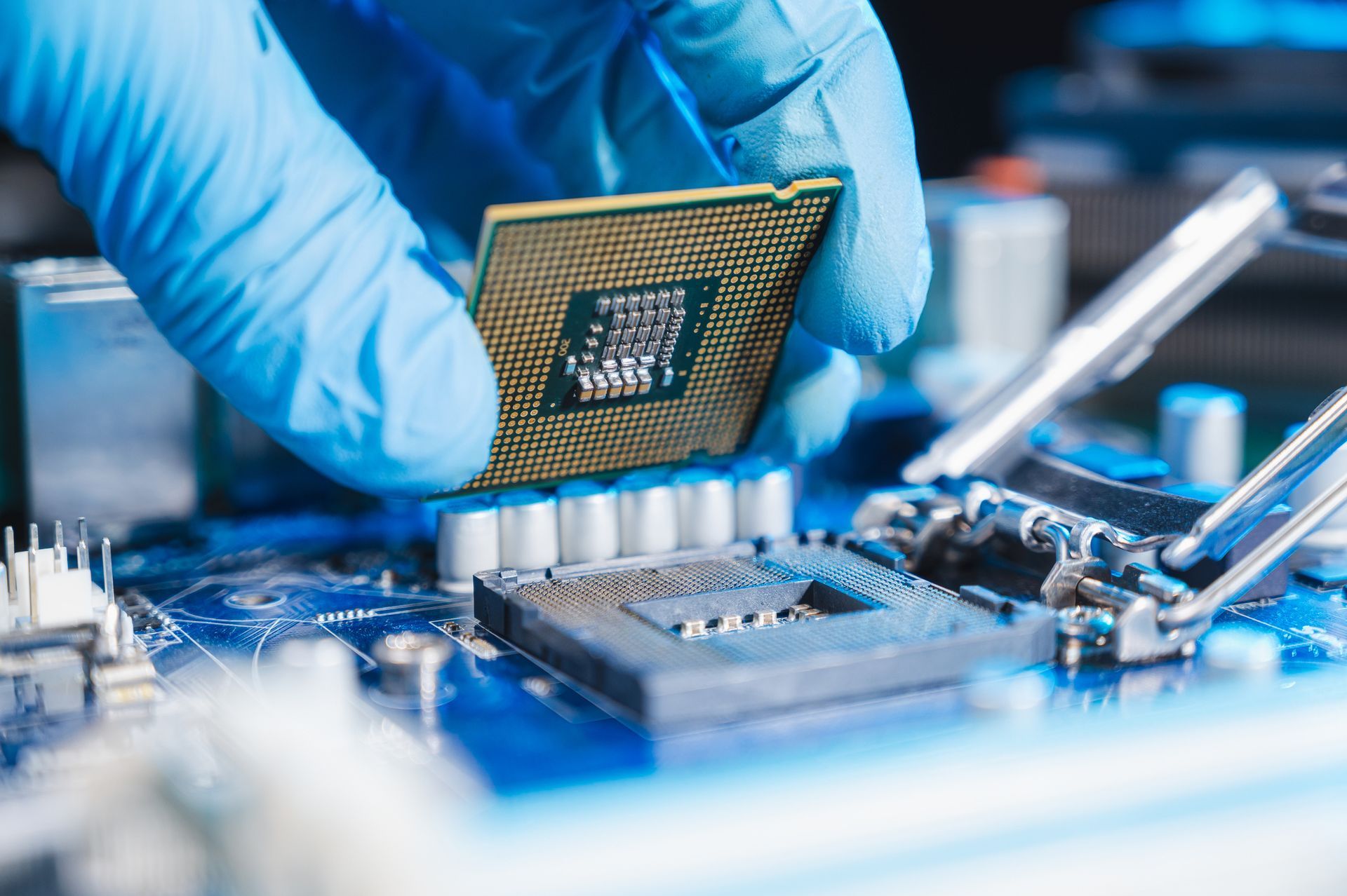 Una mano guantata inserisce una CPU nella scheda madre di un computer.