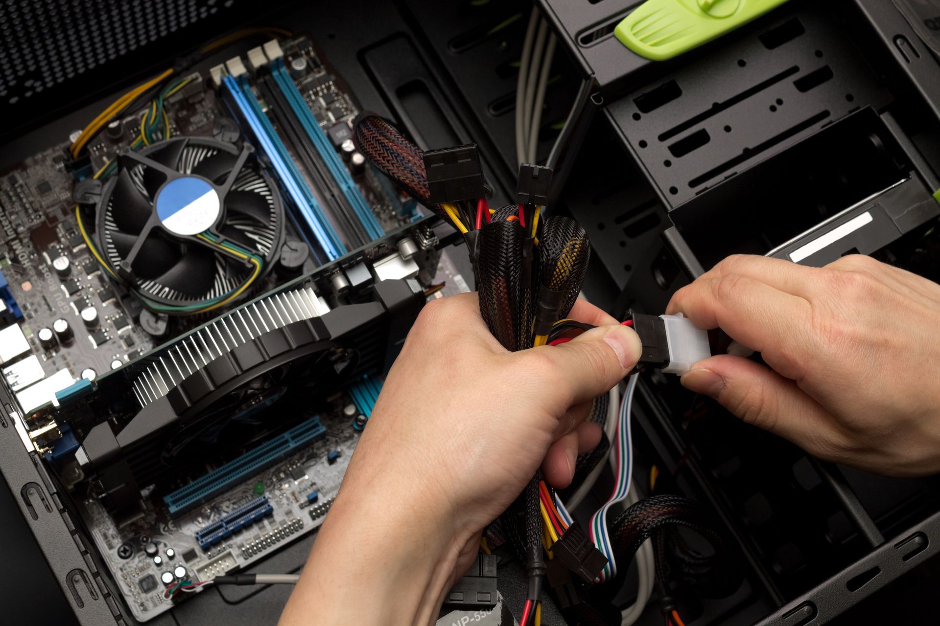 Persona che collega il cavo di alimentazione ai componenti del computer all'interno del case di un computer desktop.