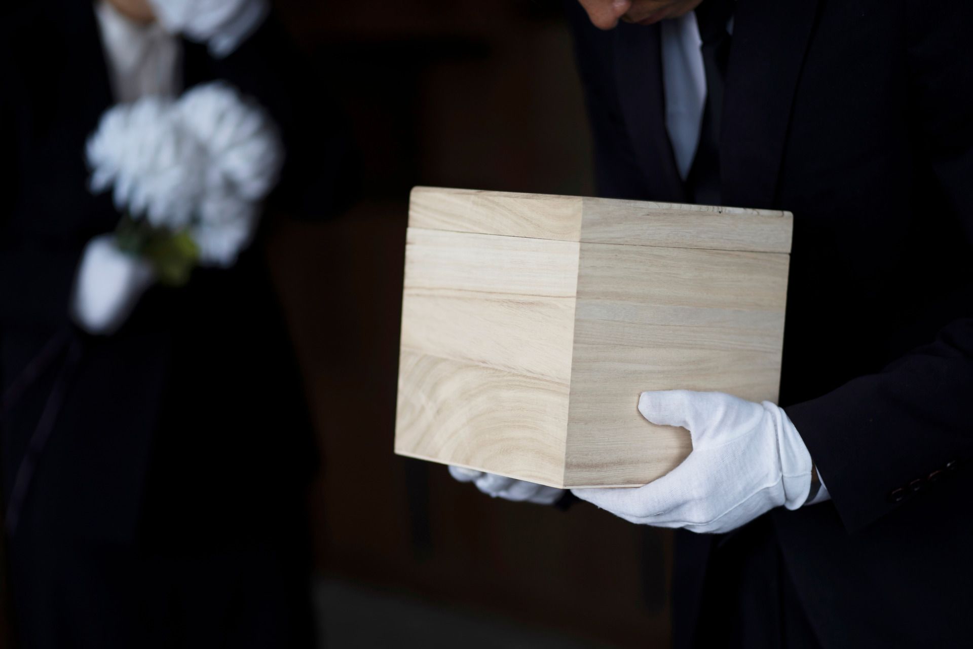 A black can is sitting on a table next to a vase of flowers.