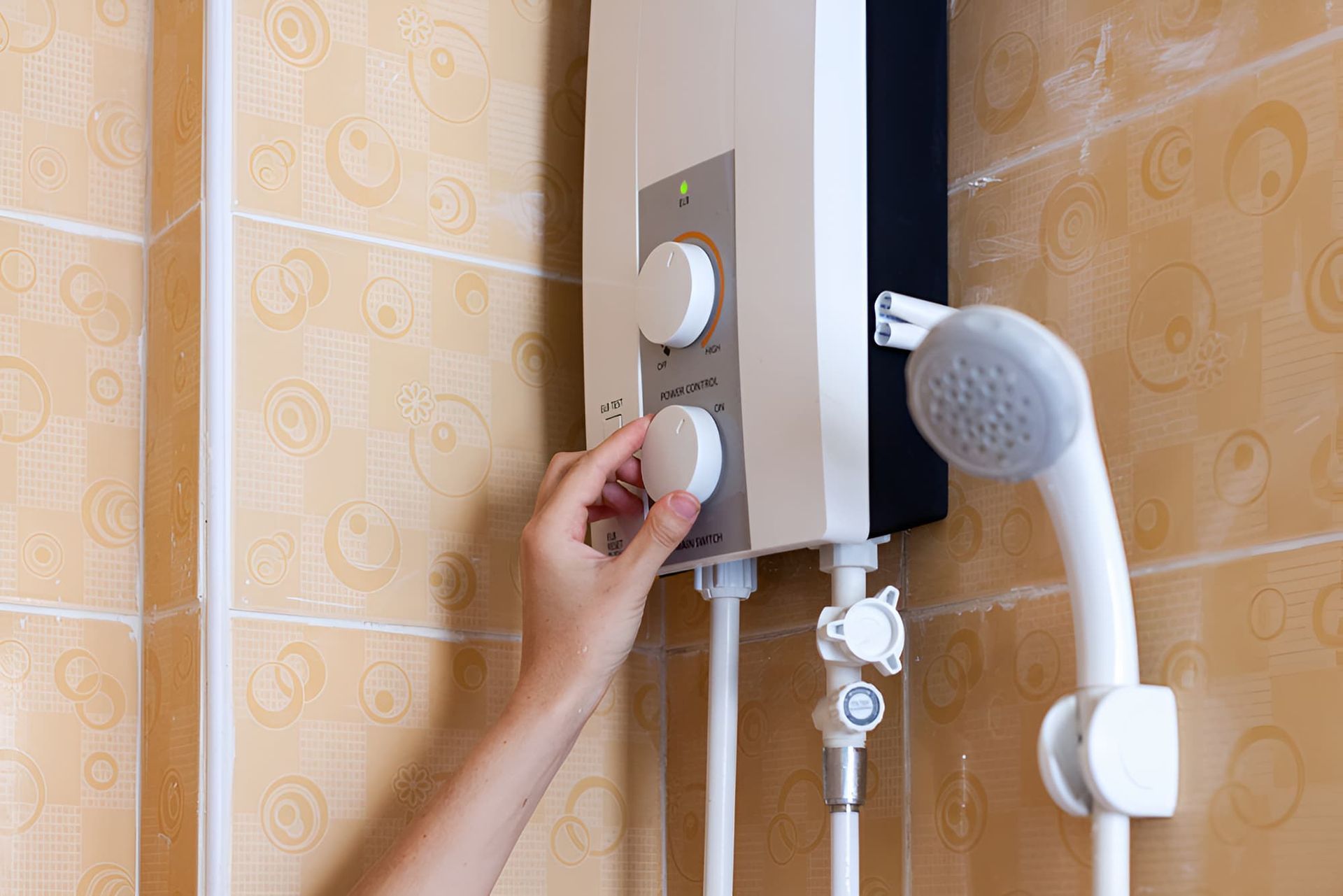 A Person is Adjusting a Water Heater in a Bathroom — John Day Plumbing in Berry Springs, NT