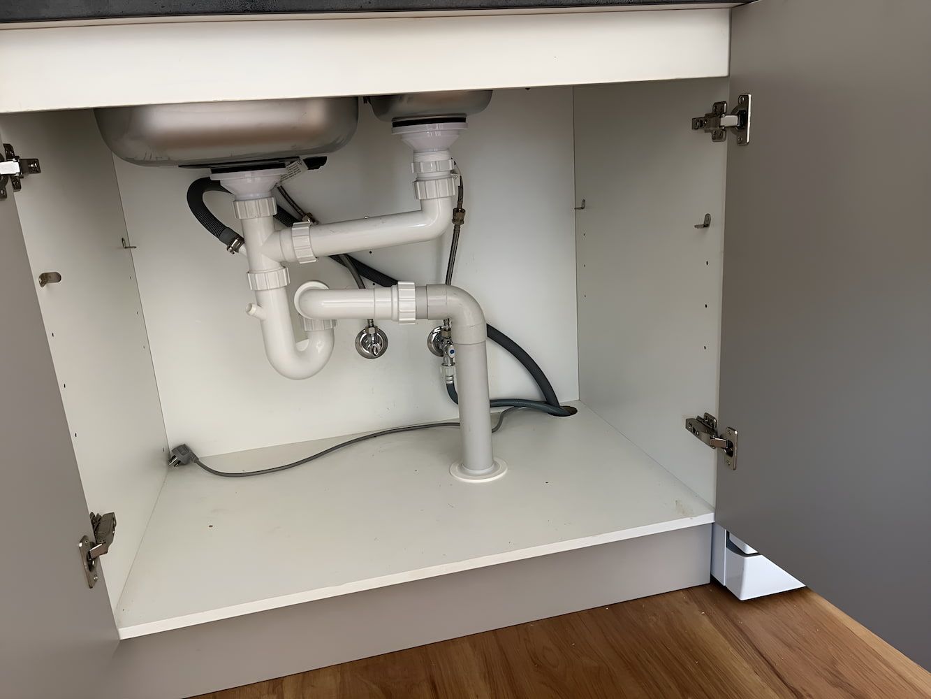 The Underside of a Kitchen Sink in a Cabinet With the Door Open — John Day Plumbing in Marlow Lagoon, NT