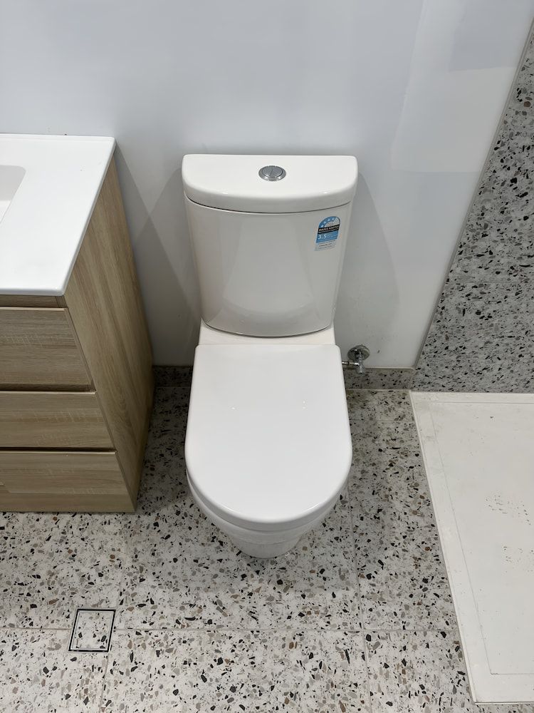 A Toilet is Sitting in a Bathroom Next to a Sink — John Day Plumbing in Casuarina, NT