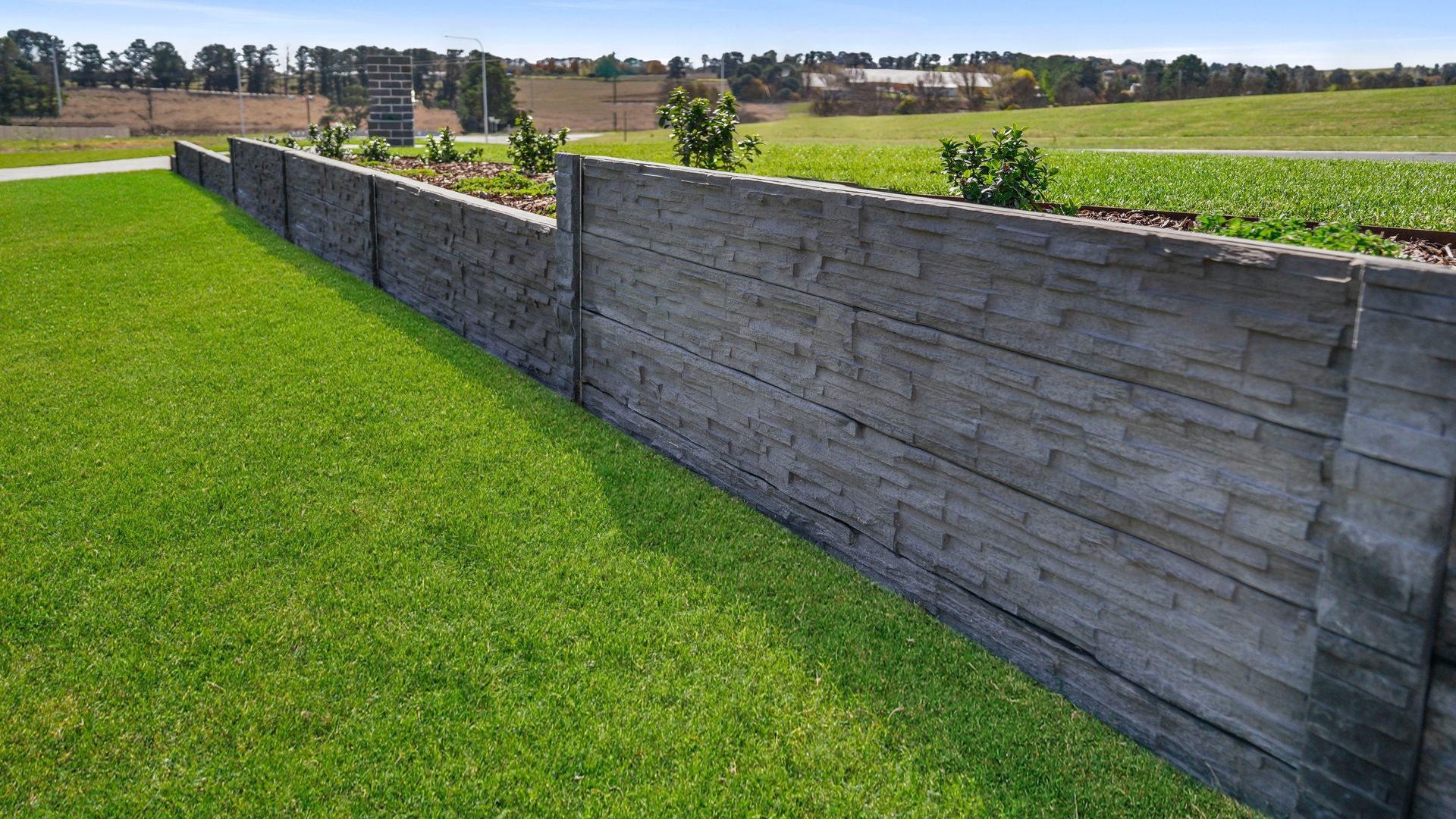 Formal landscape construction in Bathurst NSW- concrete sleeper retaining walls, native-exotic garden beds and manicured lawn