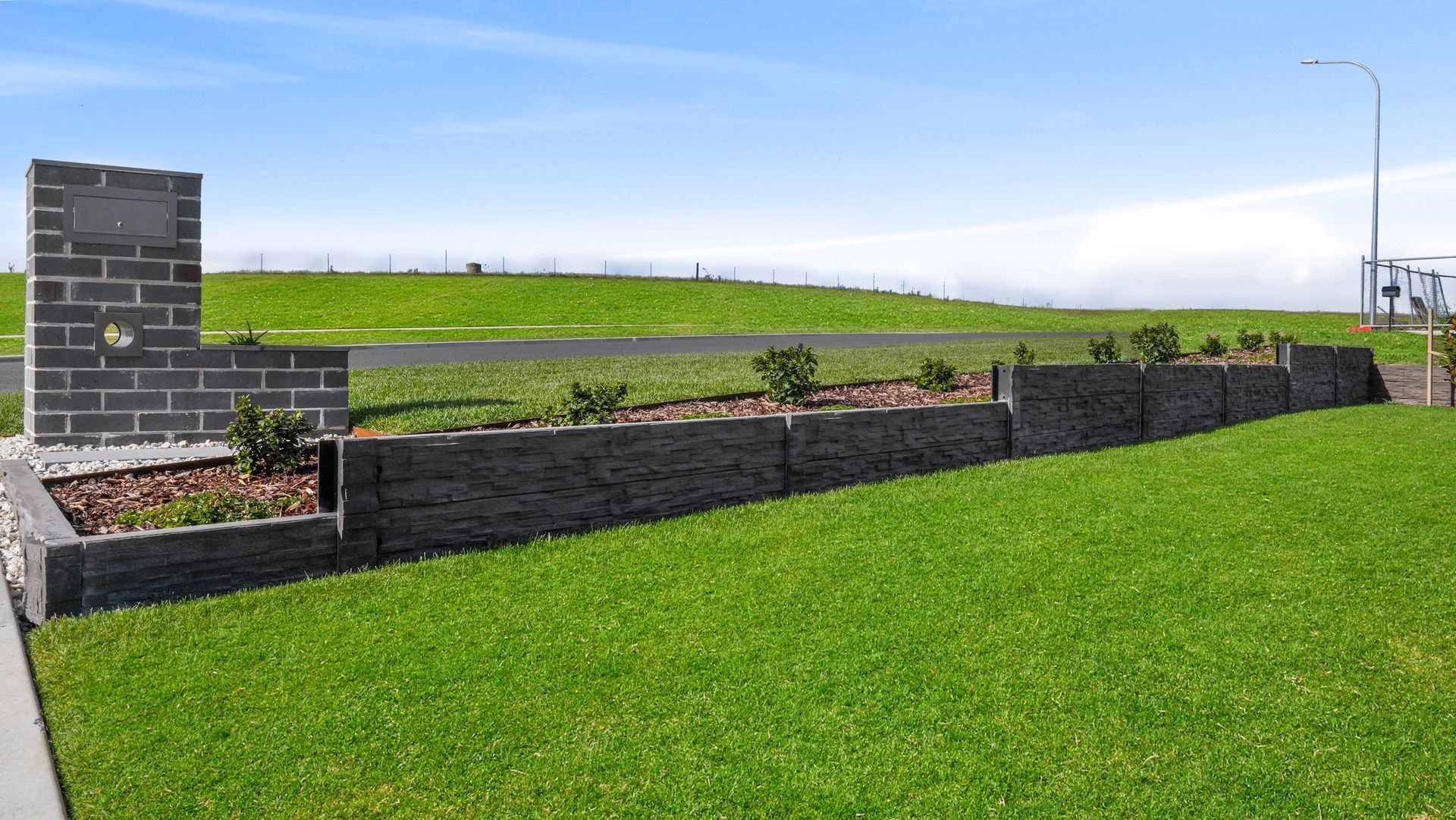 Formal landscape construction in Bathurst NSW- concrete sleeper retaining walls, native-exotic garden beds and manicured lawn