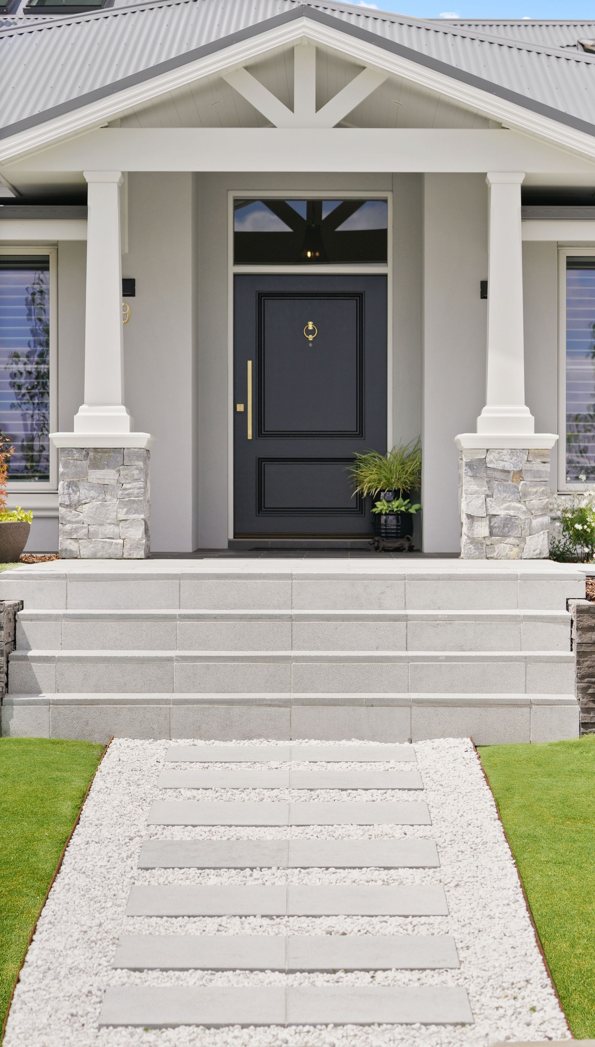 Paved stairs and paving area in a modern residential landscape construction with stone cladding feature piers 