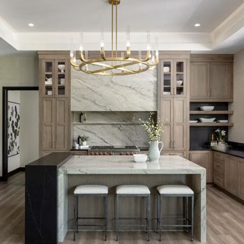 A kitchen with a large island and a chandelier hanging from the ceiling