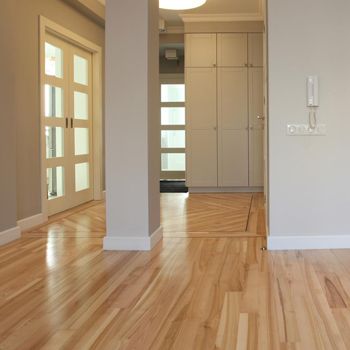 A hallway with hardwood floors and a phone on the wall