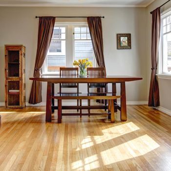 A dining room with a wooden table and chairs