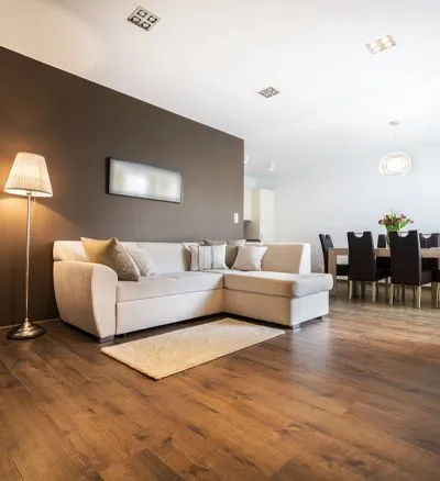 A living room with a sectional couch and a lamp.