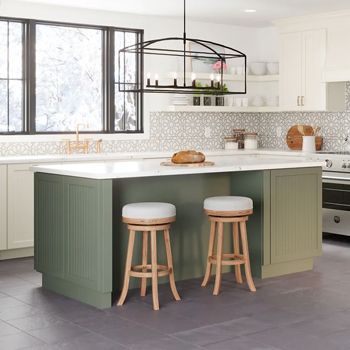 A kitchen with a green island and two wooden stools.