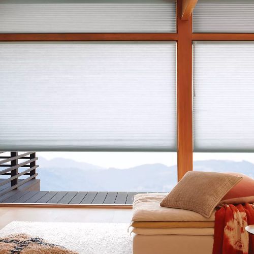 A living room with a couch and a large window with blinds.