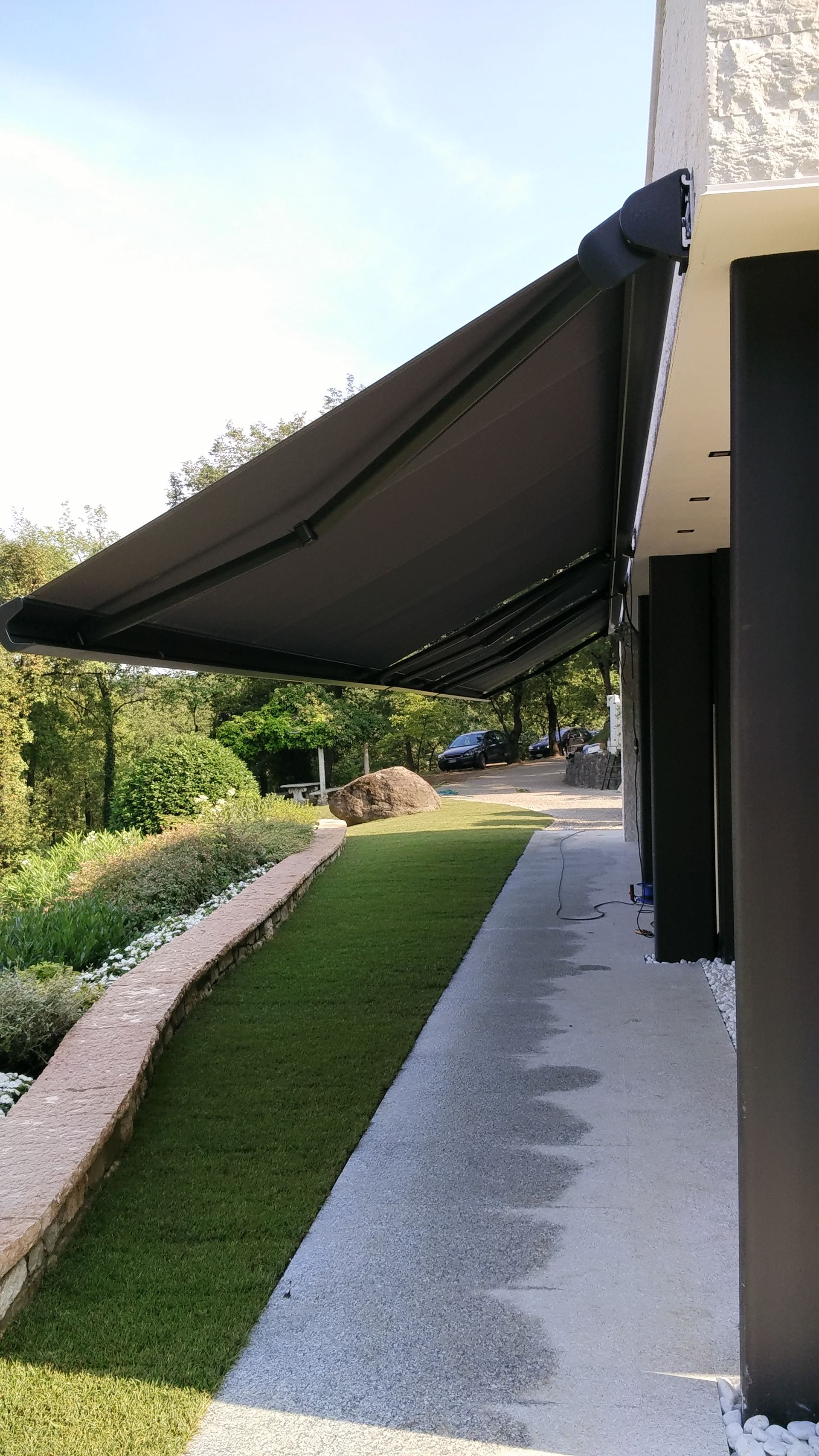 Una tenda nera ombreggia il vialetto di un edificio