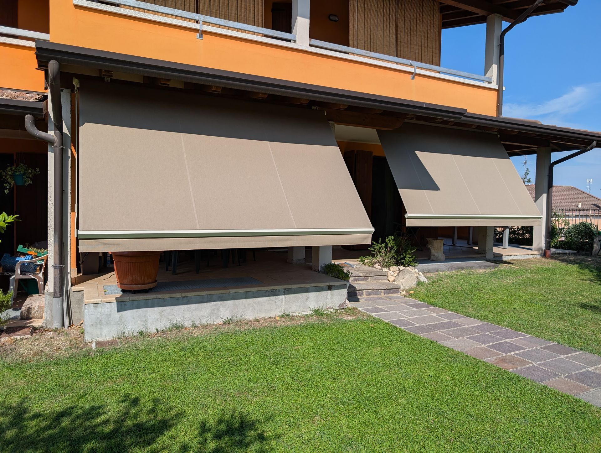 Tende beige che ombreggiano il portico di una casa