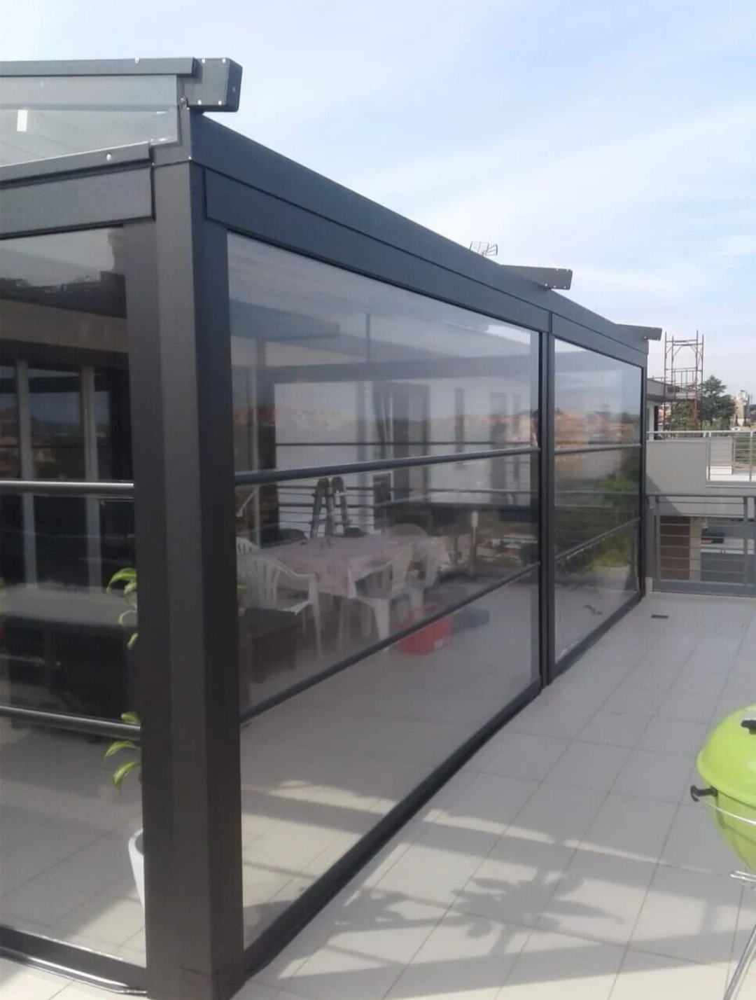 Veranda con pareti in vetro su una terrazza panoramica.