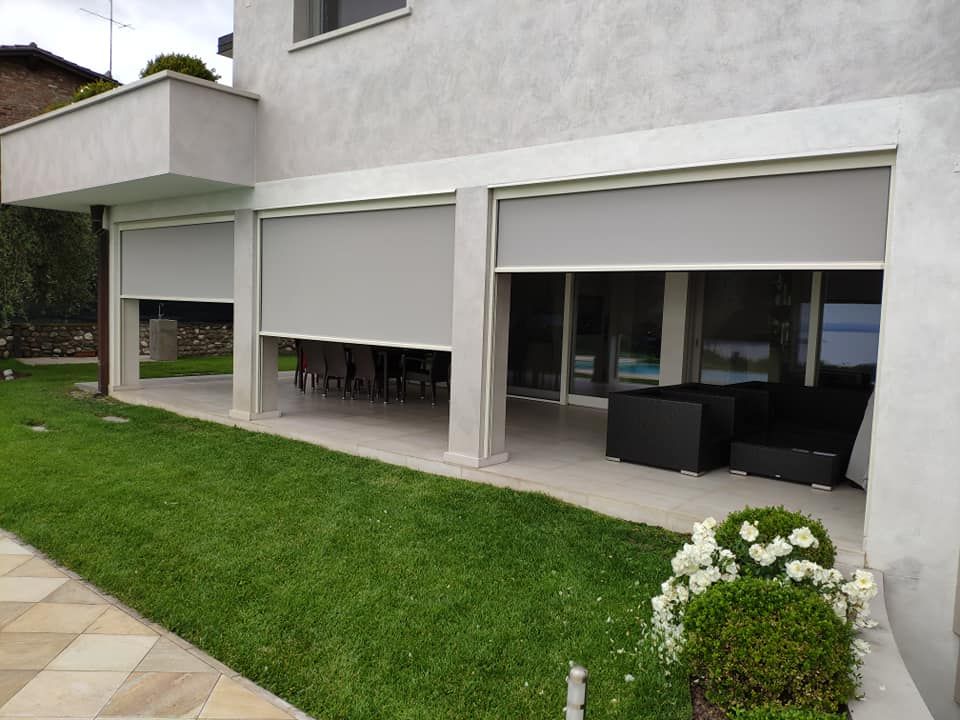 Esterno di una casa moderna con tende grigie avvolgibili